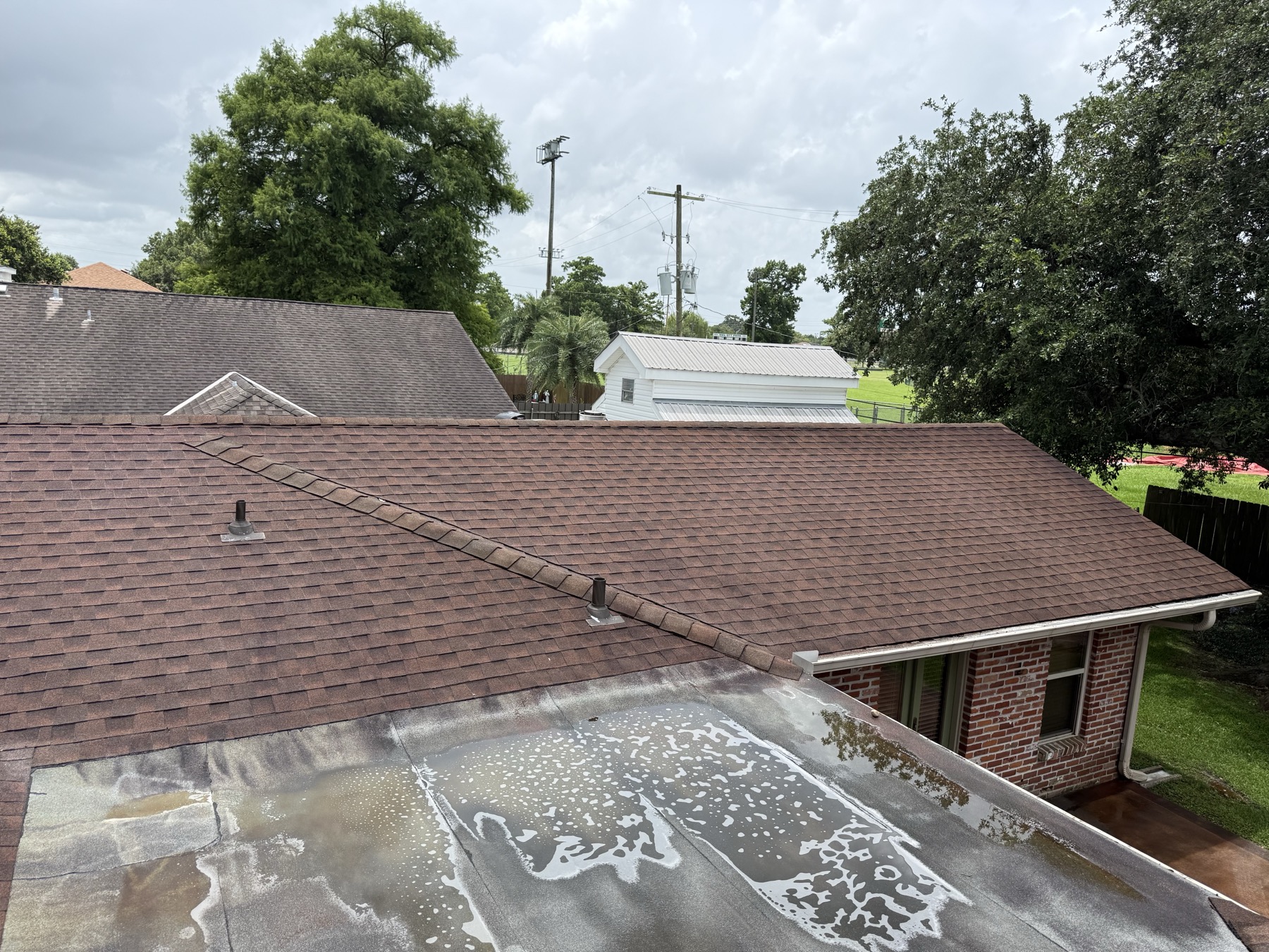 Soft wash solution running down a shingle roof